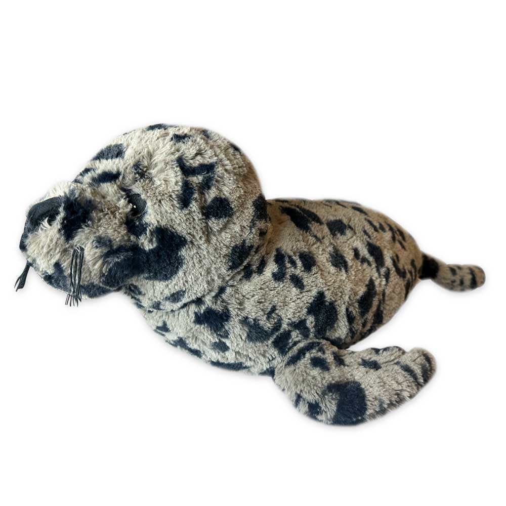 The Earth Pal Harbor Seal Plush features gray fur with black spots, rests on its belly, and is made from eco-friendly plush and recycled materials—perfect for those who value sustainability and cute design.