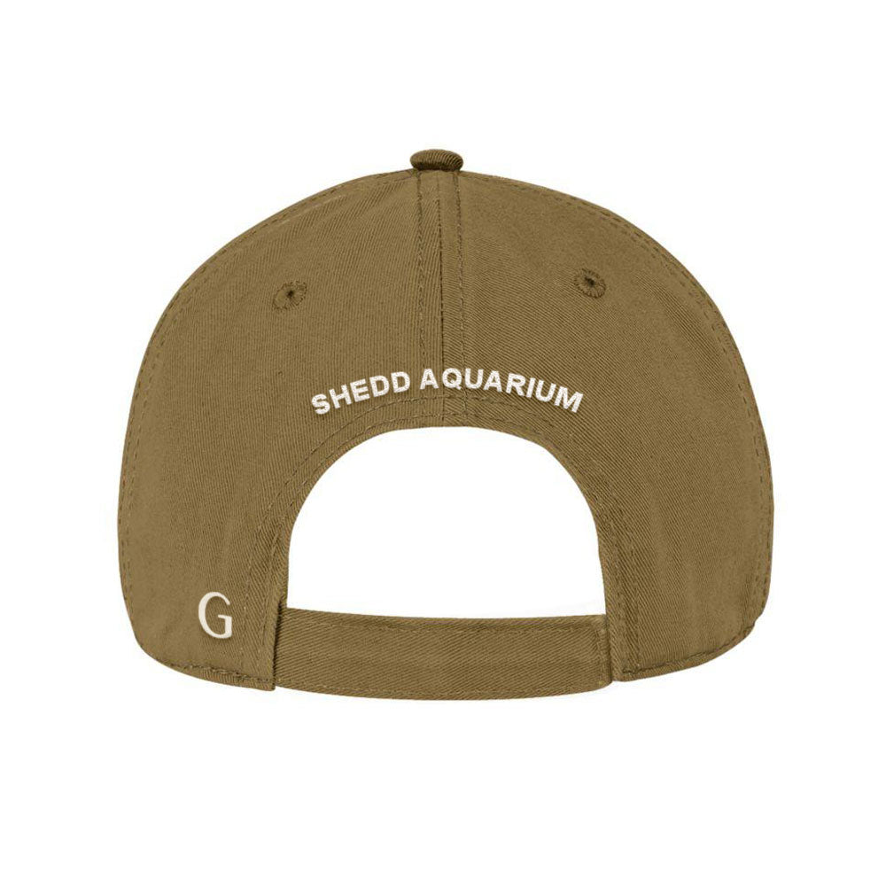 The Shedd Aquarium Chicago Cap is a khaki hat with "SHEDD AQUARIUM" in white 3D puff embroidery above the adjustable strap and a small white letter G on the lower left side—an ideal Chicago souvenir.