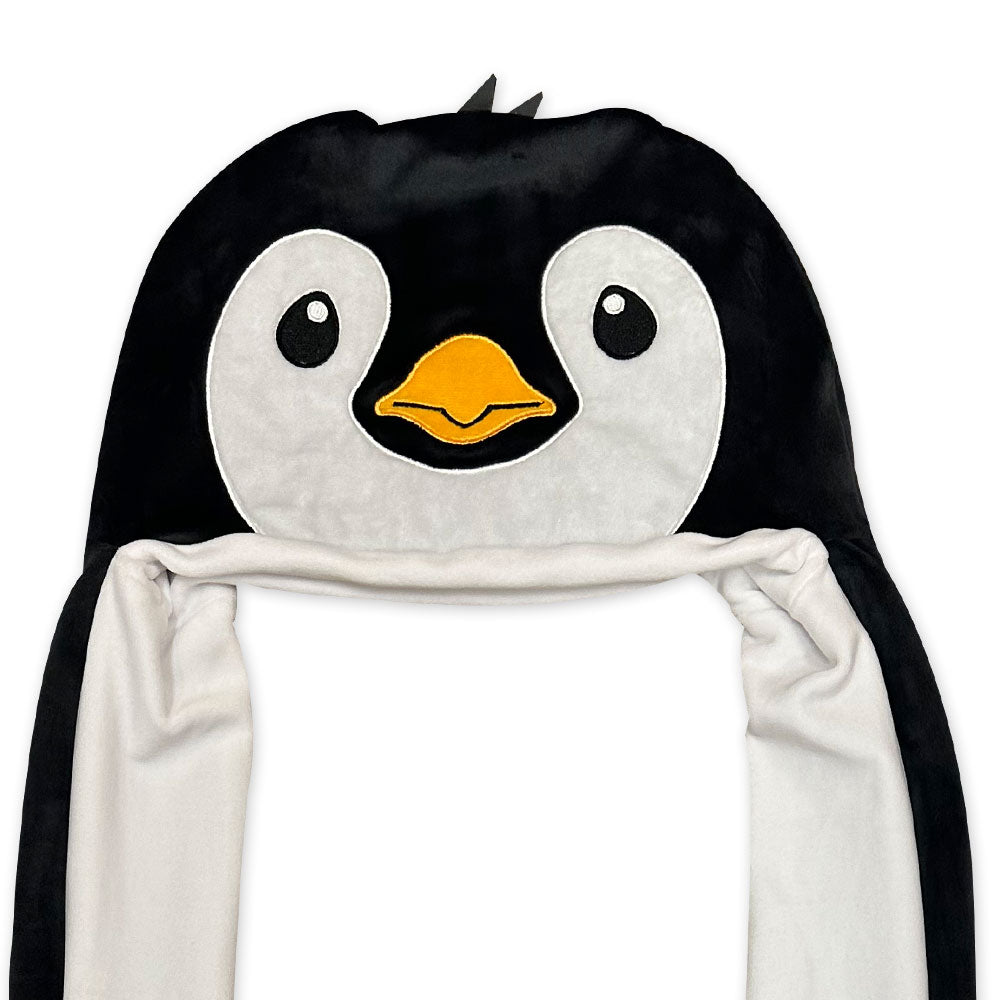 The Penguin Longpaw Hat is a plush black and white winter accessory featuring a cute embroidered face, orange beak, and white dangling flaps—perfect for staying cozy or adding fun to any costume.