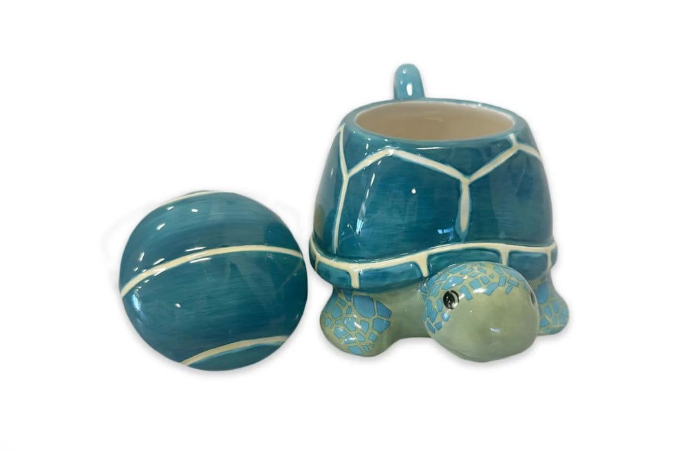 The 3D Turtle Mug With Lid, a blue and green ceramic mug with a turtle shell-shaped spill-proof lid, is shown empty next to the turtle body on a white background.