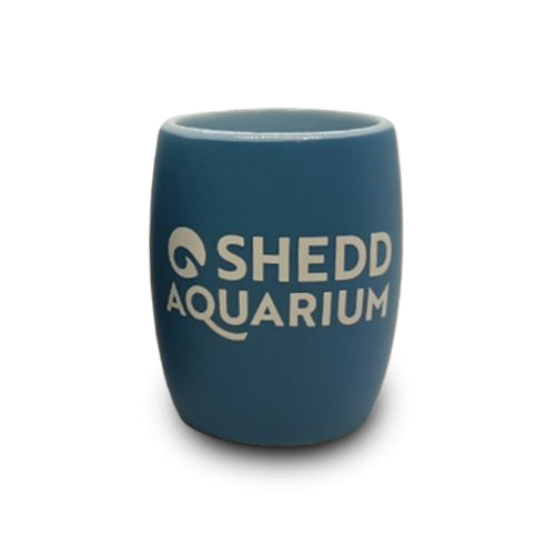A clear shot glass with an etched design featuring a penguin and the words Shedd Aquarium, making it a perfect wildlife keepsake for ocean lovers.