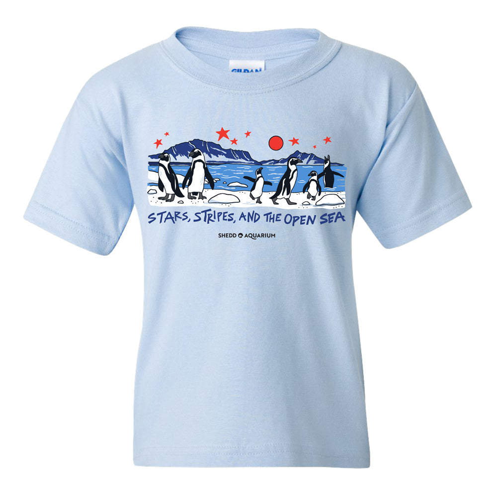 Celebrate America’s 250th with the Shedd Aquarium Stars Stripe & Open Sea Youth T-Shirt, featuring playful penguins, red stars, ocean waves, a mountain, and the inspiring slogan “STARS, STRIPES, AND THE OPEN SEA.”.