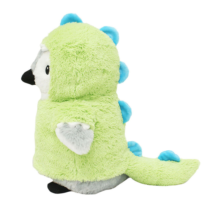 A plush penguin toy is dressed in the Plushy’s Closet Dino Outfit, a fuzzy green costume featuring blue spikes along the back and tail, and is shown in profile facing left.