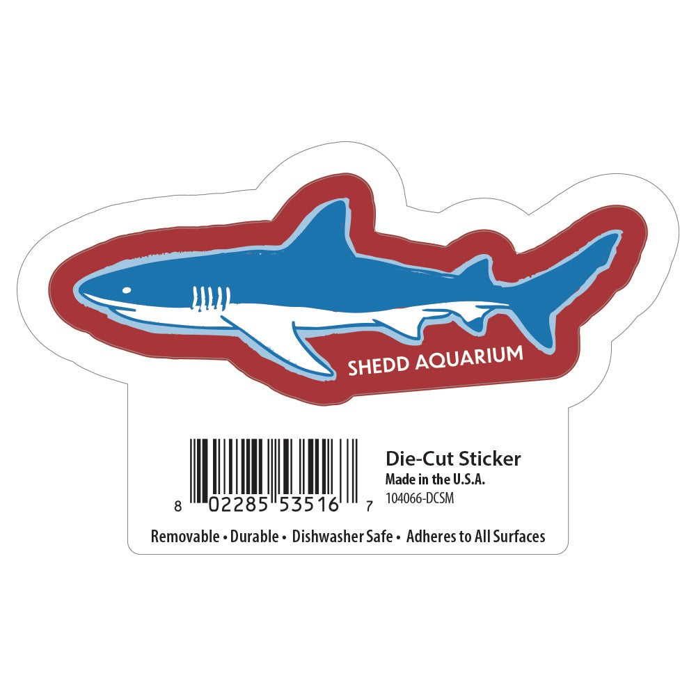 The Shedd Aquarium Red White & Ocean Blue Shark Sticker features a blue shark with a red outline and "SHEDD AQUARIUM" text, plus a barcode and details about its marine conservation support.