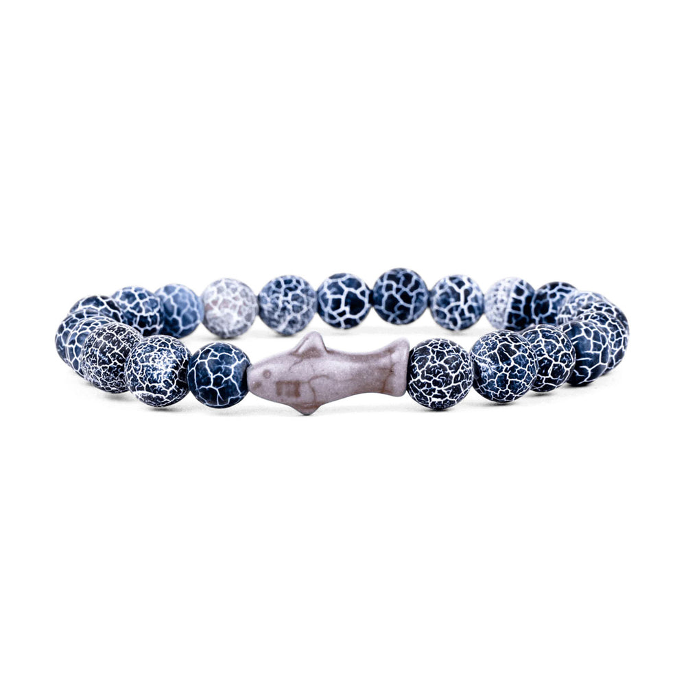 The Fahlo Shark Tracking Bracelet features round blue and white crackle beads with a central gray fish-shaped bead, arranged in a circle—an ideal accessory inspired by Shedd Aquarium for shark conservation support.