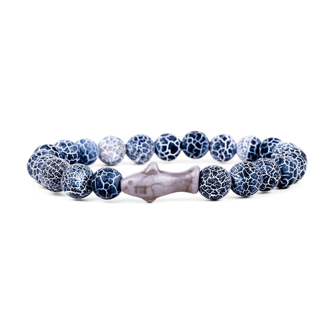 The Fahlo Shark Tracking Bracelet features round blue and white crackle beads with a central gray fish-shaped bead, arranged in a circle—an ideal accessory inspired by Shedd Aquarium for shark conservation support.