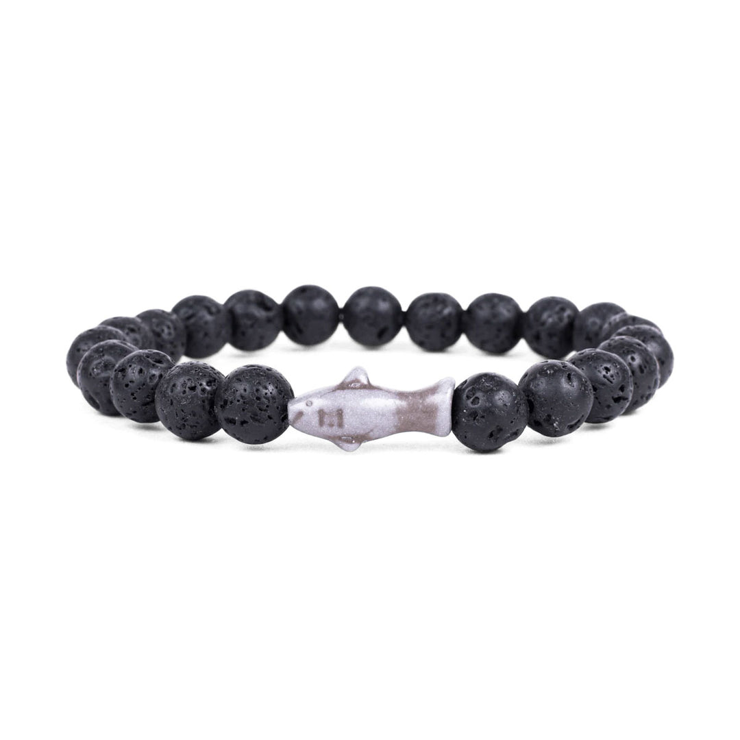 The Fahlo Shark Tracking Bracelet features round black lava stones with a metallic shark-shaped bead at the center, shown on a white background.