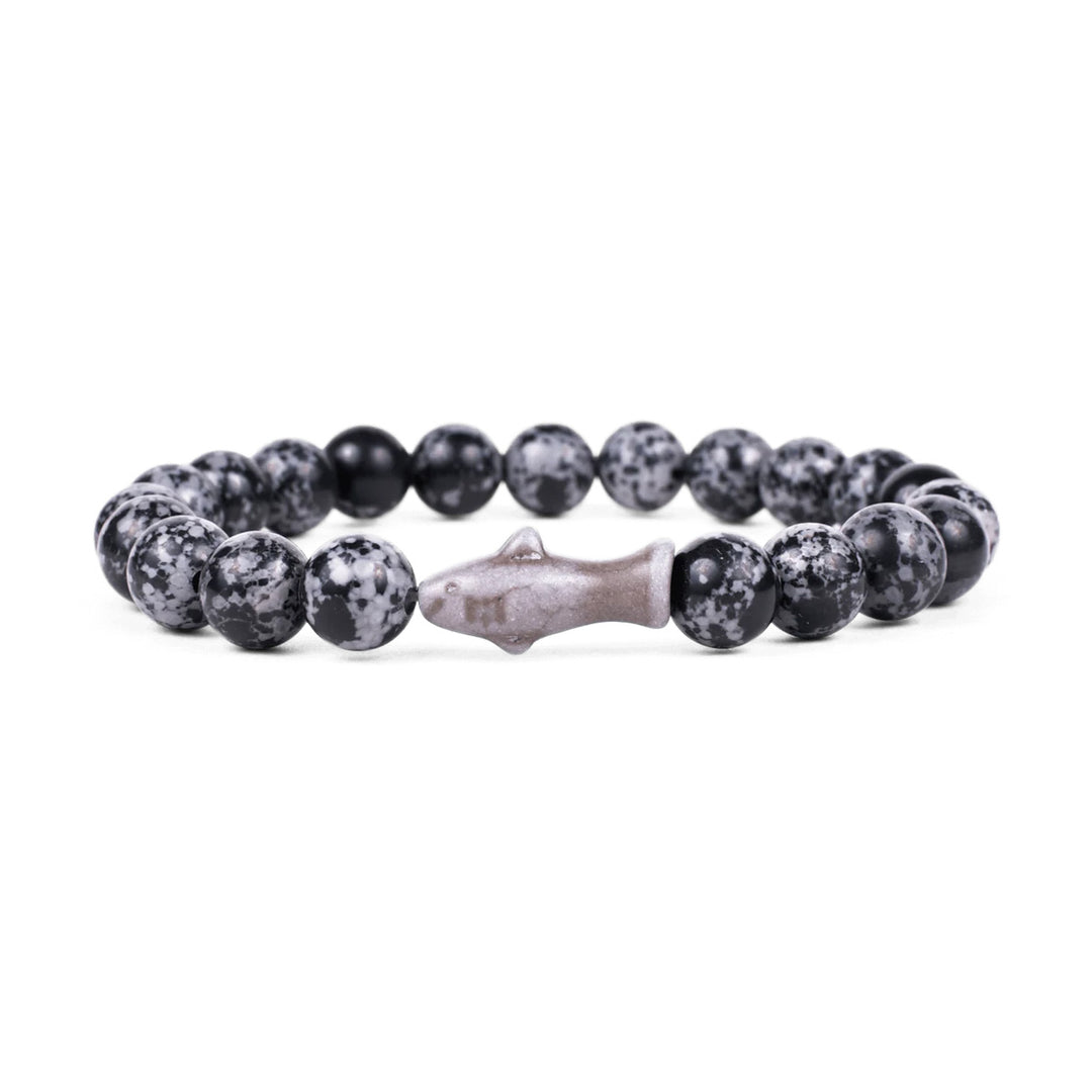 The Fahlo Shark Tracking Bracelet features round black and gray speckled beads with a central shark-shaped bead, displayed on a white background.