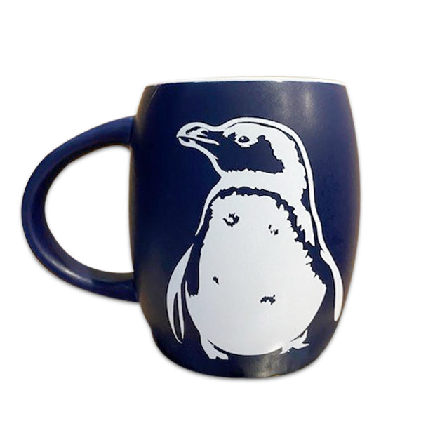 The Blue Shedd Aquarium Penguin Mug is a dark blue ceramic mug with a white penguin illustration on the side, displayed against a white background.
